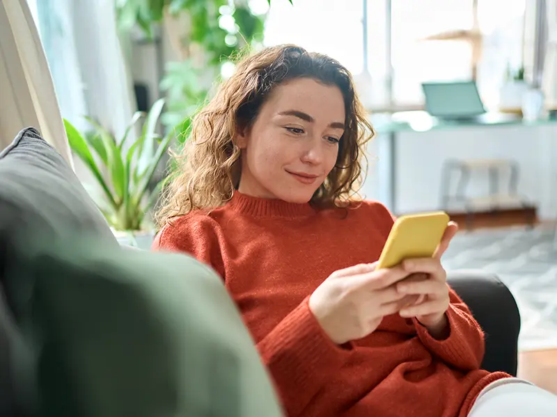 girl on couch on banking on phone